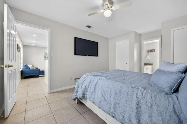 a spacious bedroom with a bed and a flat screen tv