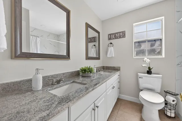 a bathroom with granite countertop sink and mirror