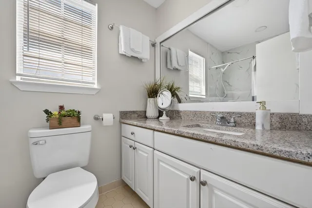 an empty room with wooden floor chandelier fan and windows