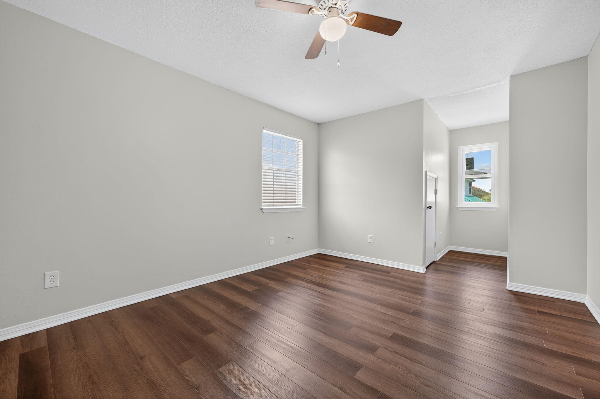 150 Beach Drive Fort Walton Beach, FL 32547 - Photo 39 of 56 an empty room with wooden floor chandelier fan and windows
