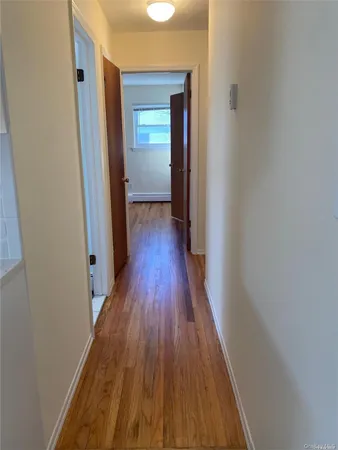 a view of a hallway with wooden floor