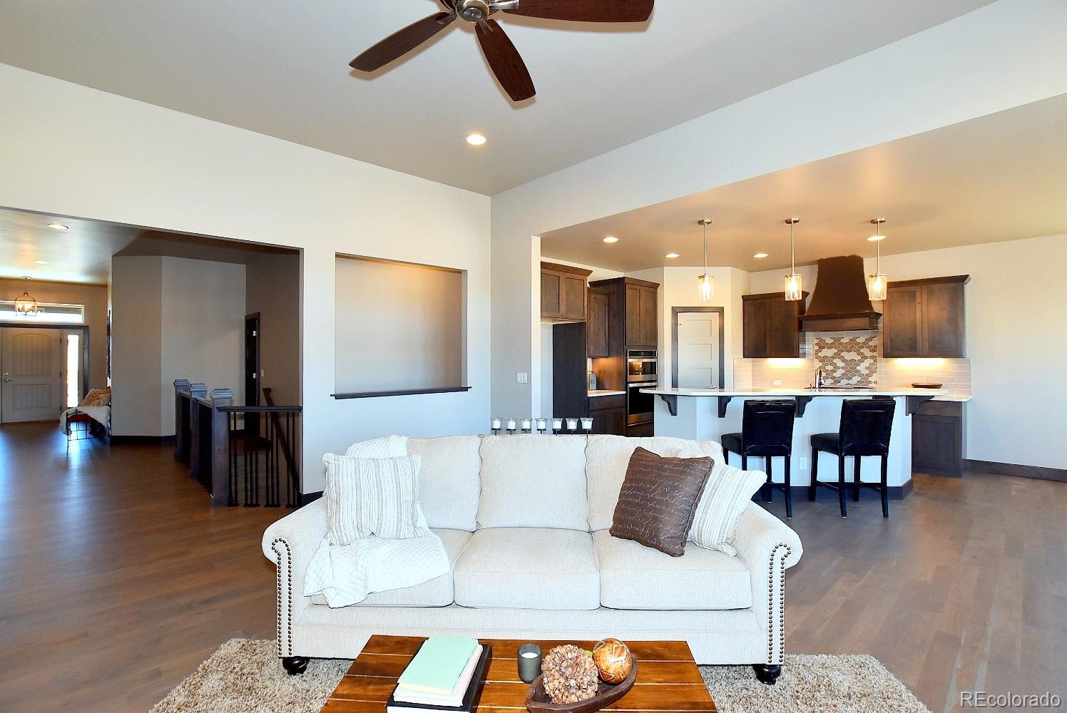4792 Mariana Ridge Court Loveland, CO 80537 - Photo 11 of 39 a living room with furniture and a dining table with wooden floor