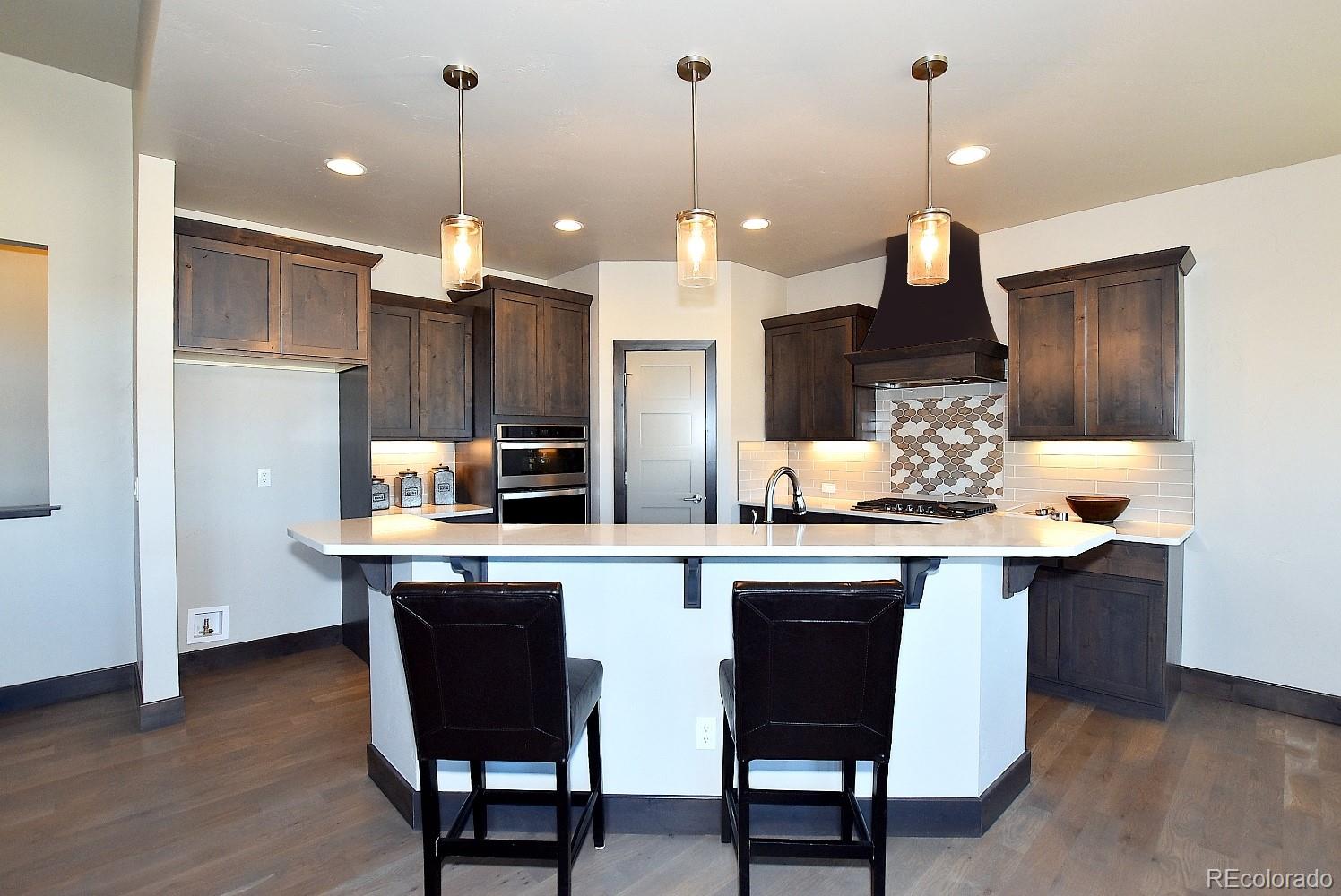 4792 Mariana Ridge Court Loveland, CO 80537 - Photo 13 of 39 a kitchen with stainless steel appliances granite countertop a sink a stove a refrigerator and wooden floor