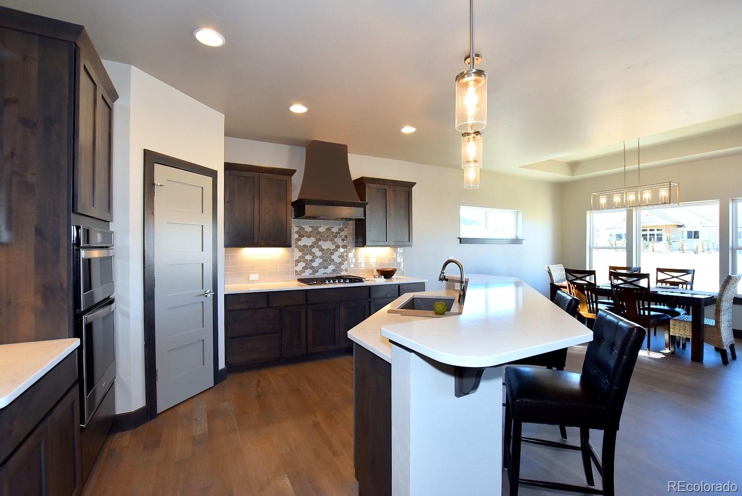 4792 Mariana Ridge Court Loveland, CO 80537 - Photo 15 of 39 a kitchen with a sink refrigerator and chairs