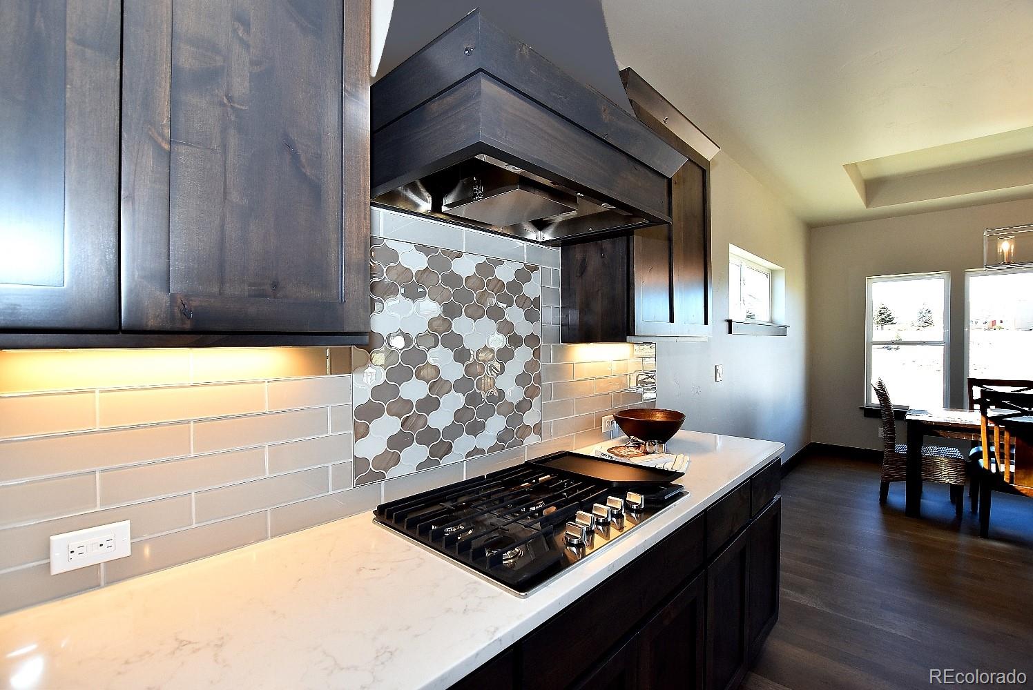 4792 Mariana Ridge Court Loveland, CO 80537 - Photo 16 of 39 a kitchen with wooden cabinets and a stove top oven