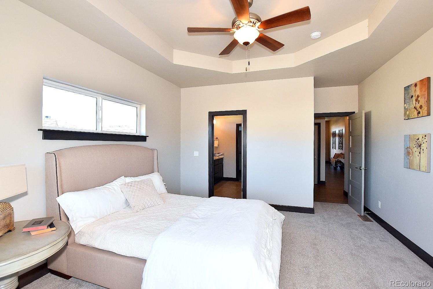 4792 Mariana Ridge Court Loveland, CO 80537 - Photo 21 of 39 a bedroom with a bed and a chandelier