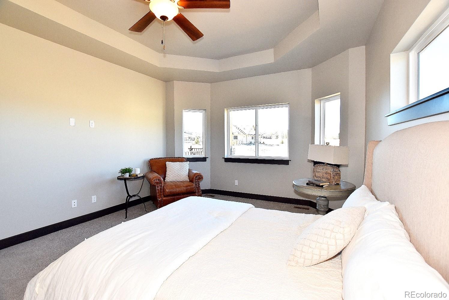 4792 Mariana Ridge Court Loveland, CO 80537 - Photo 23 of 39 a bedroom with a bed and a chandelier