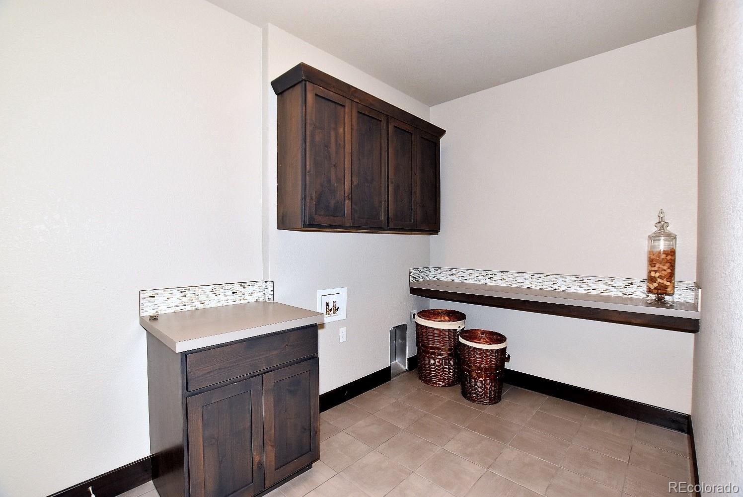 4792 Mariana Ridge Court Loveland, CO 80537 - Photo 27 of 39 a storage room with wooden cabinets