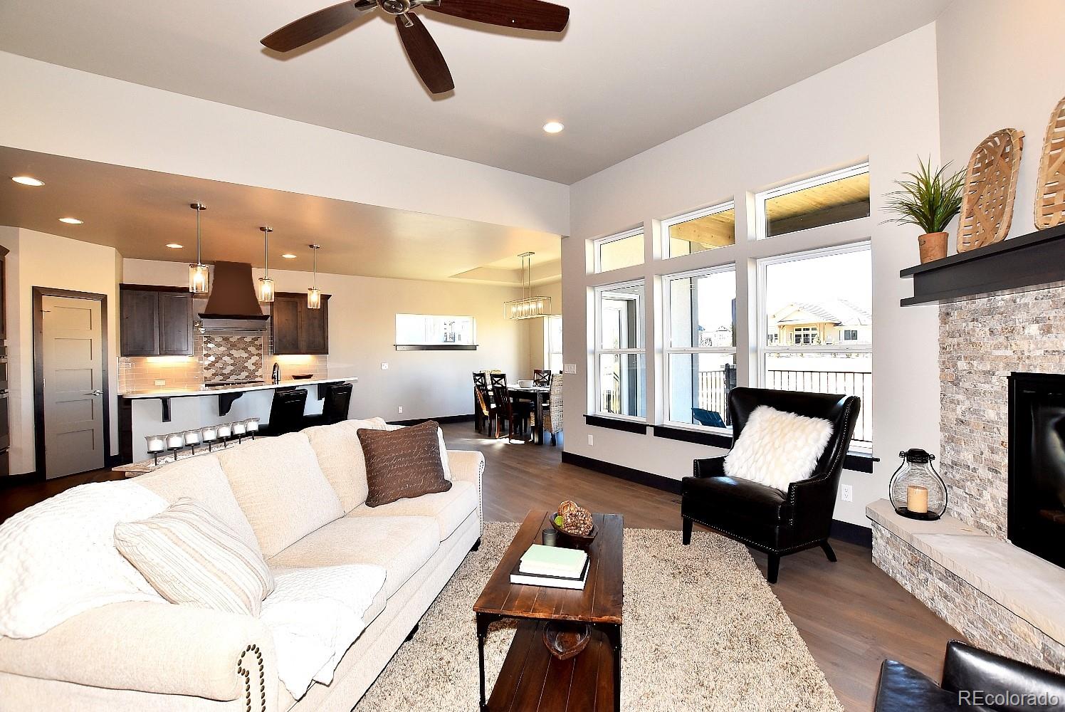 4792 Mariana Ridge Court Loveland, CO 80537 - Photo 8 of 39 a living room with furniture ceiling fan and a fireplace