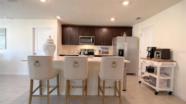 a living room with furniture a flat screen tv and kitchen view