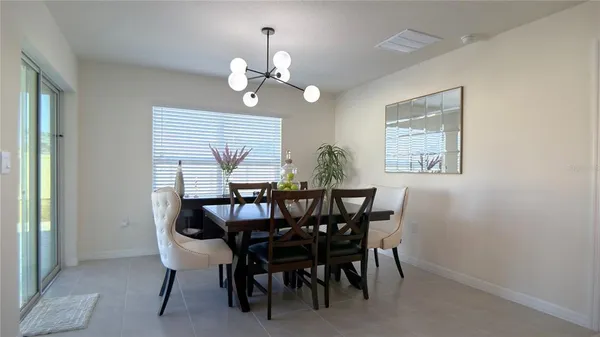 a view of a dining room with furniture a chandelier and wooden floor