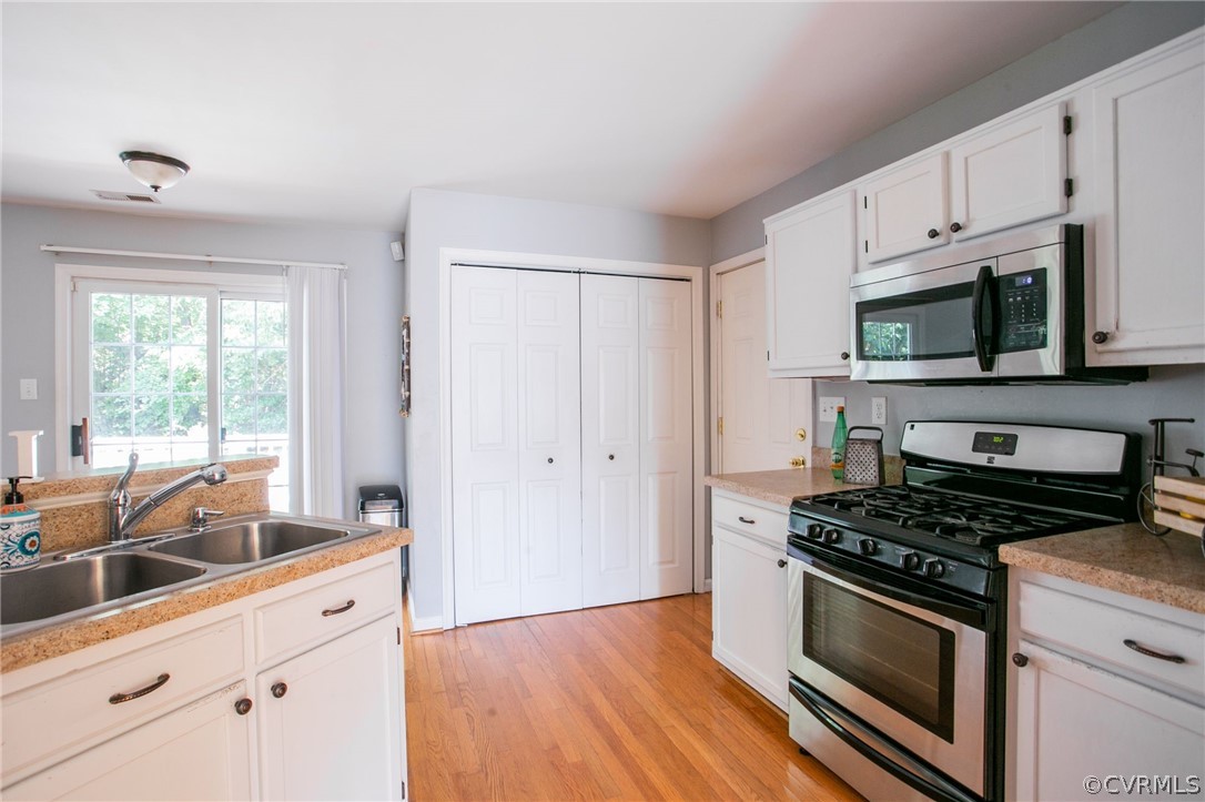 3248 Ransom Hills Road Richmond, VA 23237 - Photo 14 of 28 a kitchen with stainless steel appliances a stove a microwave and sink