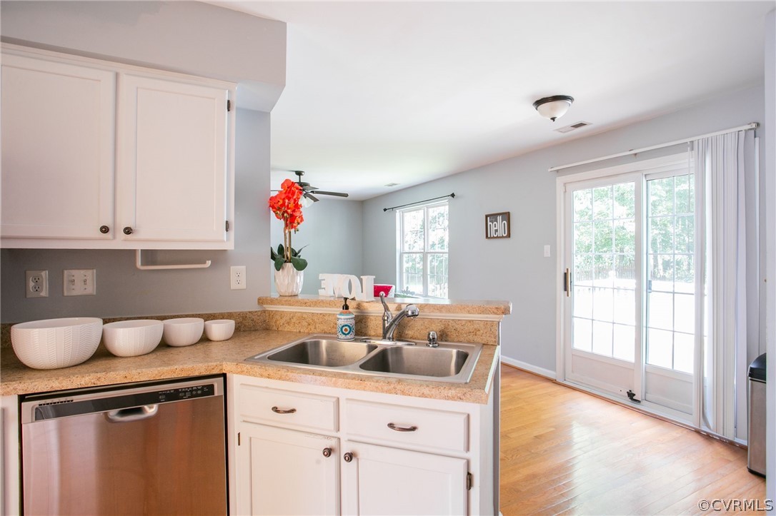 3248 Ransom Hills Road Richmond, VA 23237 - Photo 10 of 28 a kitchen with a sink dishwasher a dining table and chairs with white cabinets