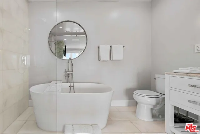 a white bath tub sitting next to a white toilet and a sink