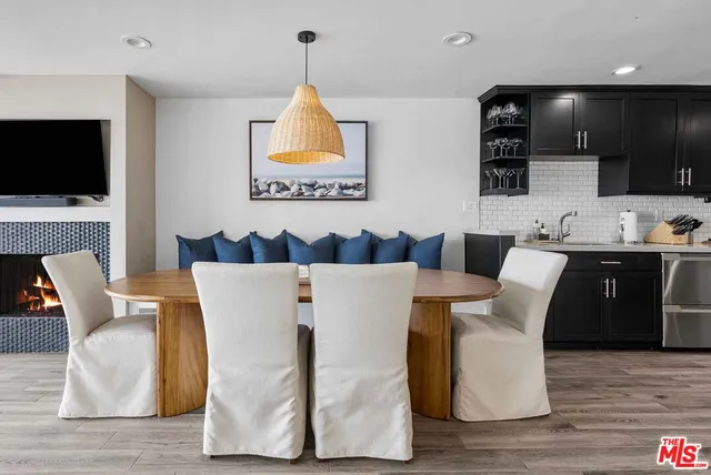 a living room with stainless steel appliances kitchen island granite countertop furniture a fireplace and a flat screen tv