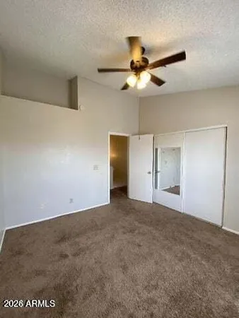an empty room with windows and ceiling fan