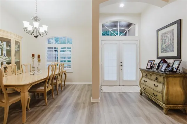a view of a dining room with furniture a chandelier and wooden floor