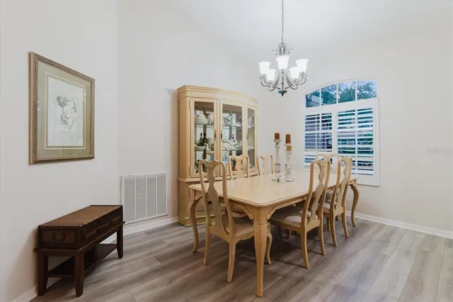 a view of a dining room with furniture wooden floor and chandelier