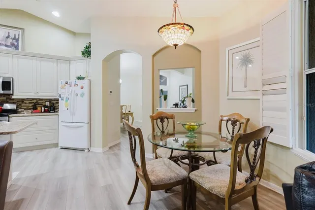 a dining room with furniture a chandelier and wooden floor