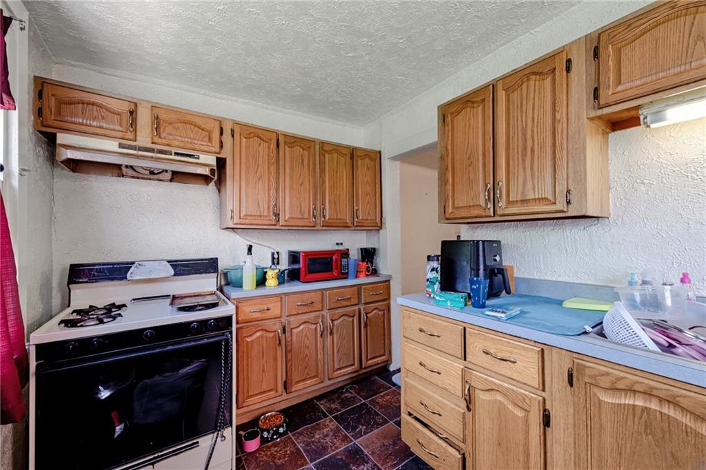 125 North Chestnut Street Butler, PA 16001 - Photo 12 of 25 a kitchen with stainless steel appliances granite countertop a stove a sink dishwasher and cabinets with wooden floor