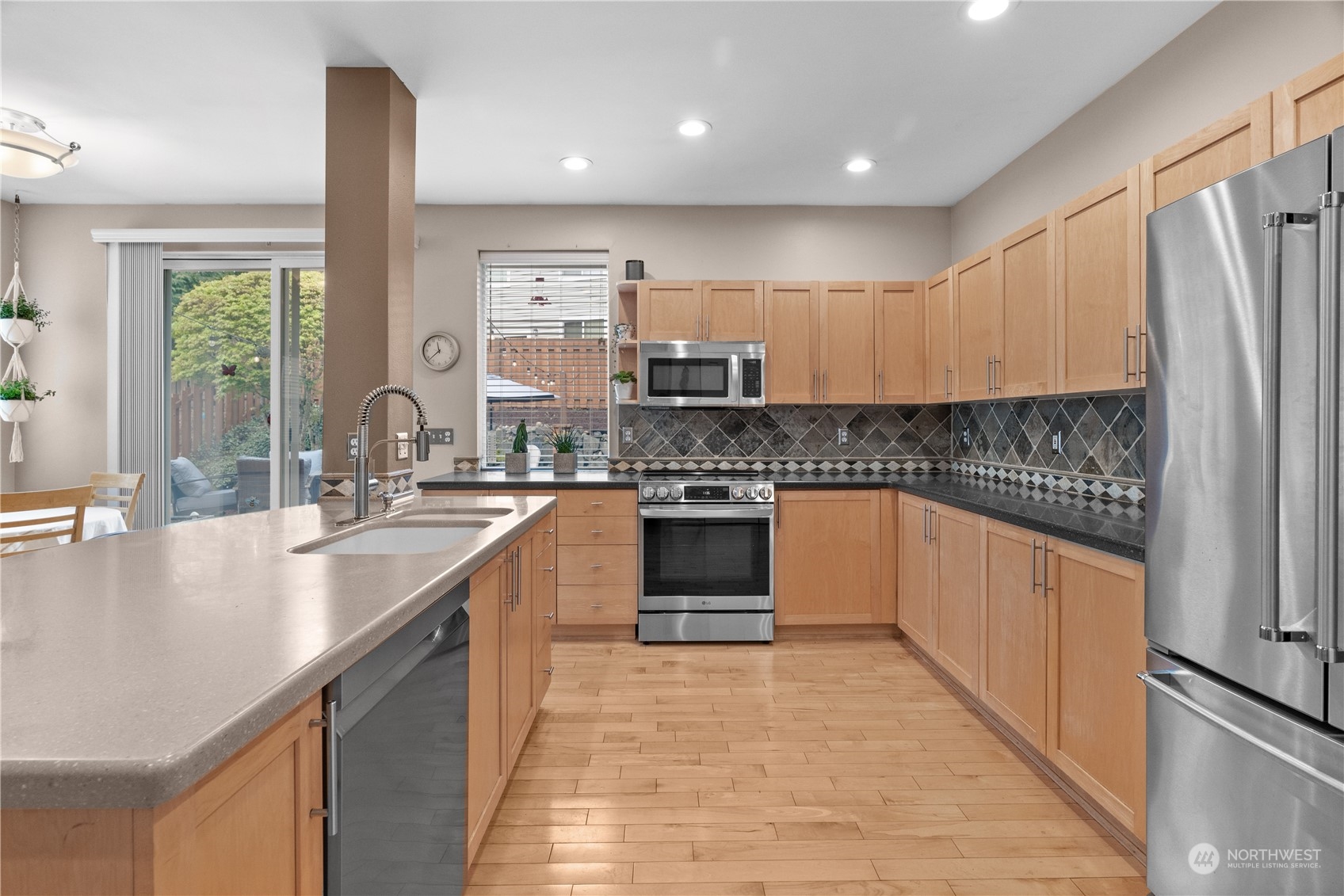 27325 Maple Ridge Way Southeast Maple Valley, WA 98038 - Photo 12 of 40 a kitchen with stainless steel appliances granite countertop a sink counter space cabinets and a large window
