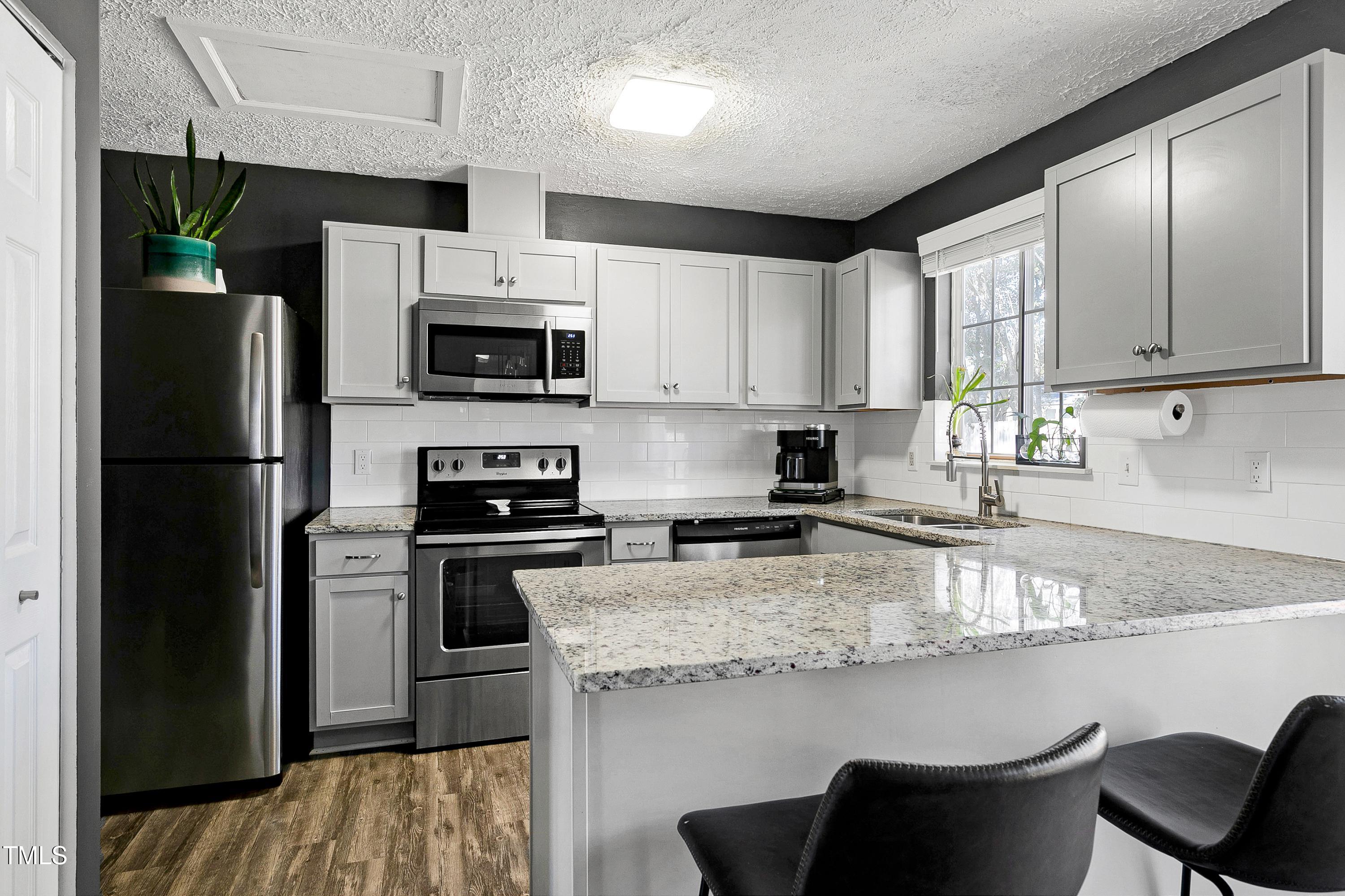 8612 Keegan Court Raleigh, NC 27613 - Photo 8 of 31 a kitchen with stainless steel appliances granite countertop a stove a refrigerator and a sink