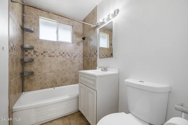 an empty room with a ceiling fan and a window