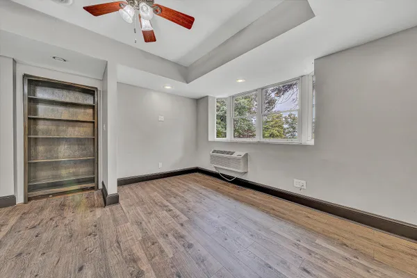 a view of a hallway with wooden floor and staircase