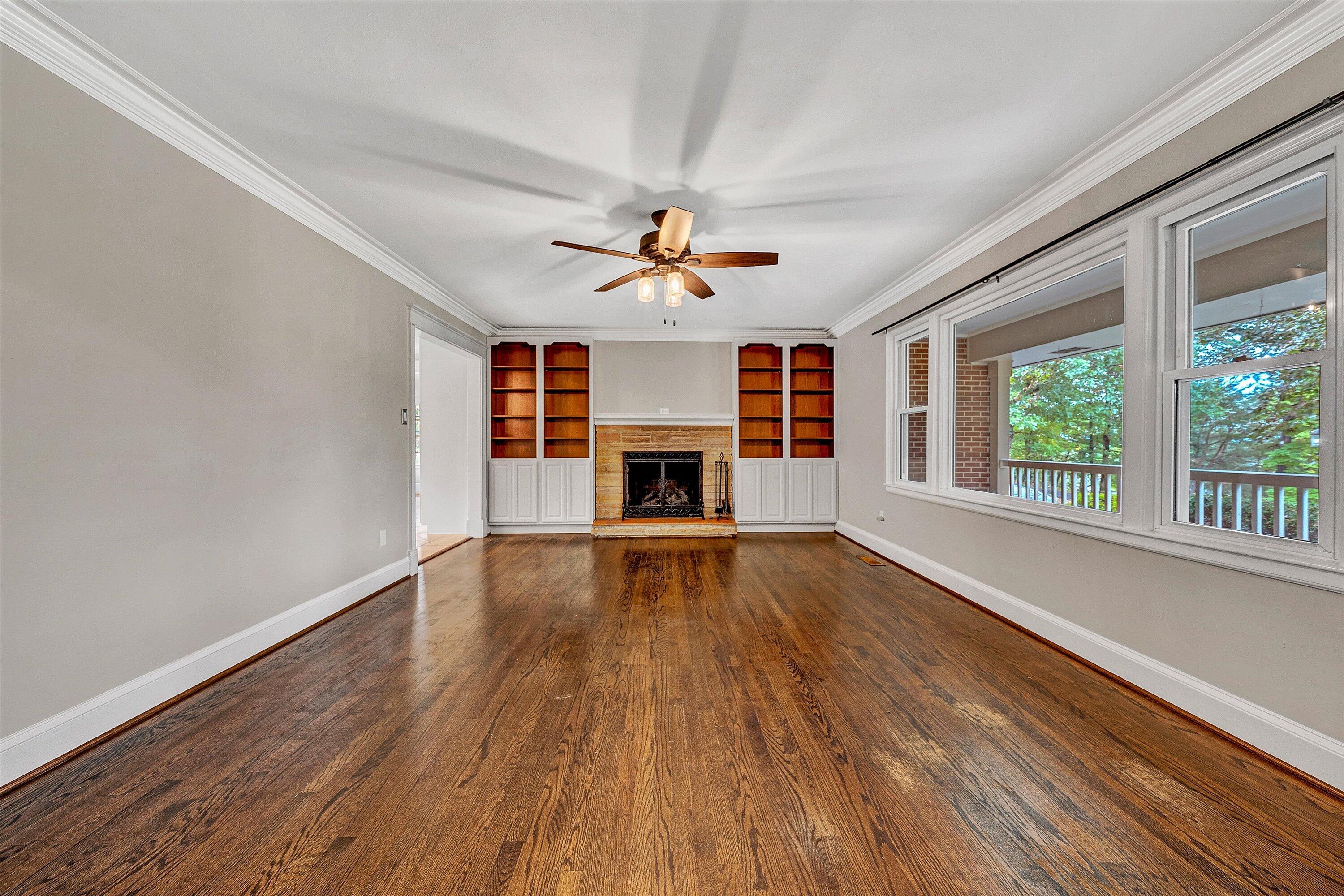83 Springview Court Troutville, VA 24175 - Photo 7 of 74 an empty room with fireplace wooden floor chandelier fan and windows