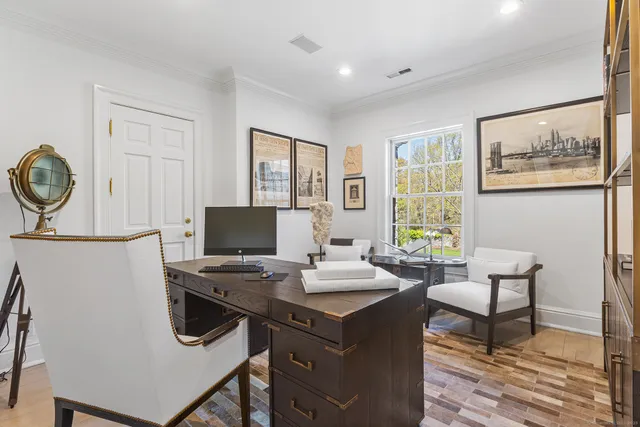 a view of a workspace with furniture and a window