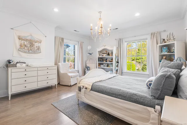 a spacious bedroom with a bed dresser and a window