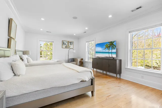 a bedroom with a bed and a dresser next to a window
