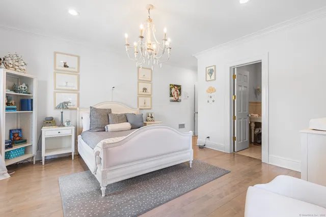 a spacious bedroom with a bed and a chandelier