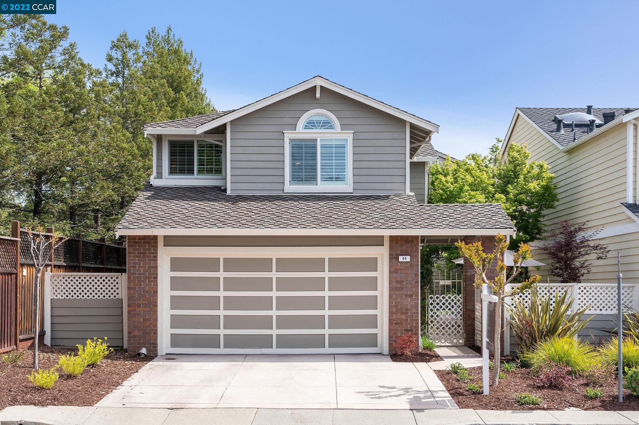 a front view of a house with a garden and garage