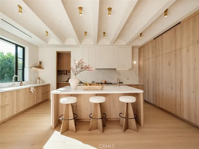 a kitchen with a stove a table and chairs in it