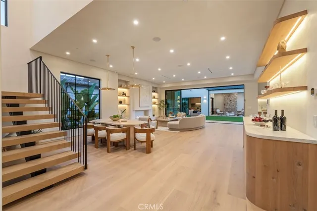 a view of a livingroom with wooden floor and a bathroom
