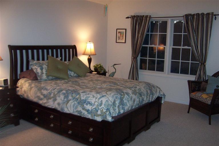 16 Gold Leaf Lane, Unit 16 Mashpee, MA 02649 - Photo 21 of 29 a bed sitting in a bedroom next to a large window