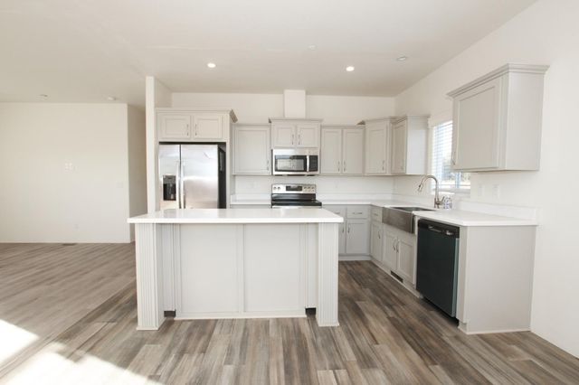a kitchen with wooden floors white cabinets and appliances