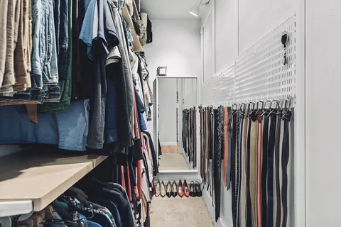 a view of walk in closet with clothes