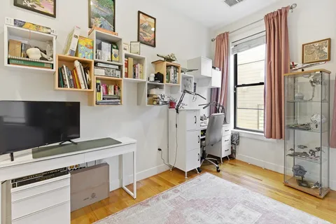a view of a livingroom with workspace and a window