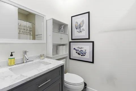 a bathroom with a toilet a sink and mirror