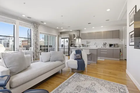 a living room with furniture and kitchen view