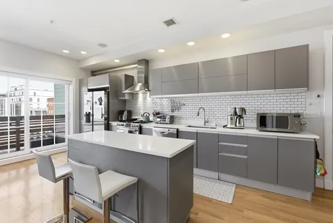 a kitchen with kitchen island a stove a table and chairs in it