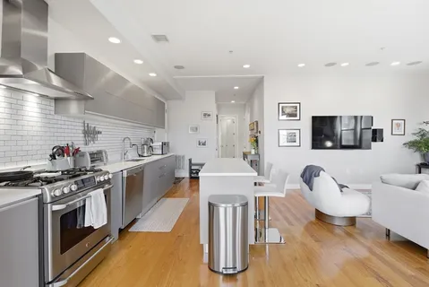 a kitchen with a table chairs stove and wooden floor