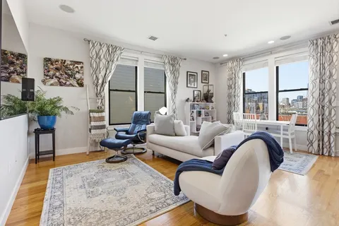 a living room with furniture fireplace and a potted plant