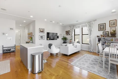 a living room with fireplace furniture and a view of kitchen