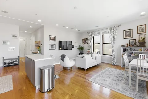 a living room with fireplace furniture and a view of kitchen