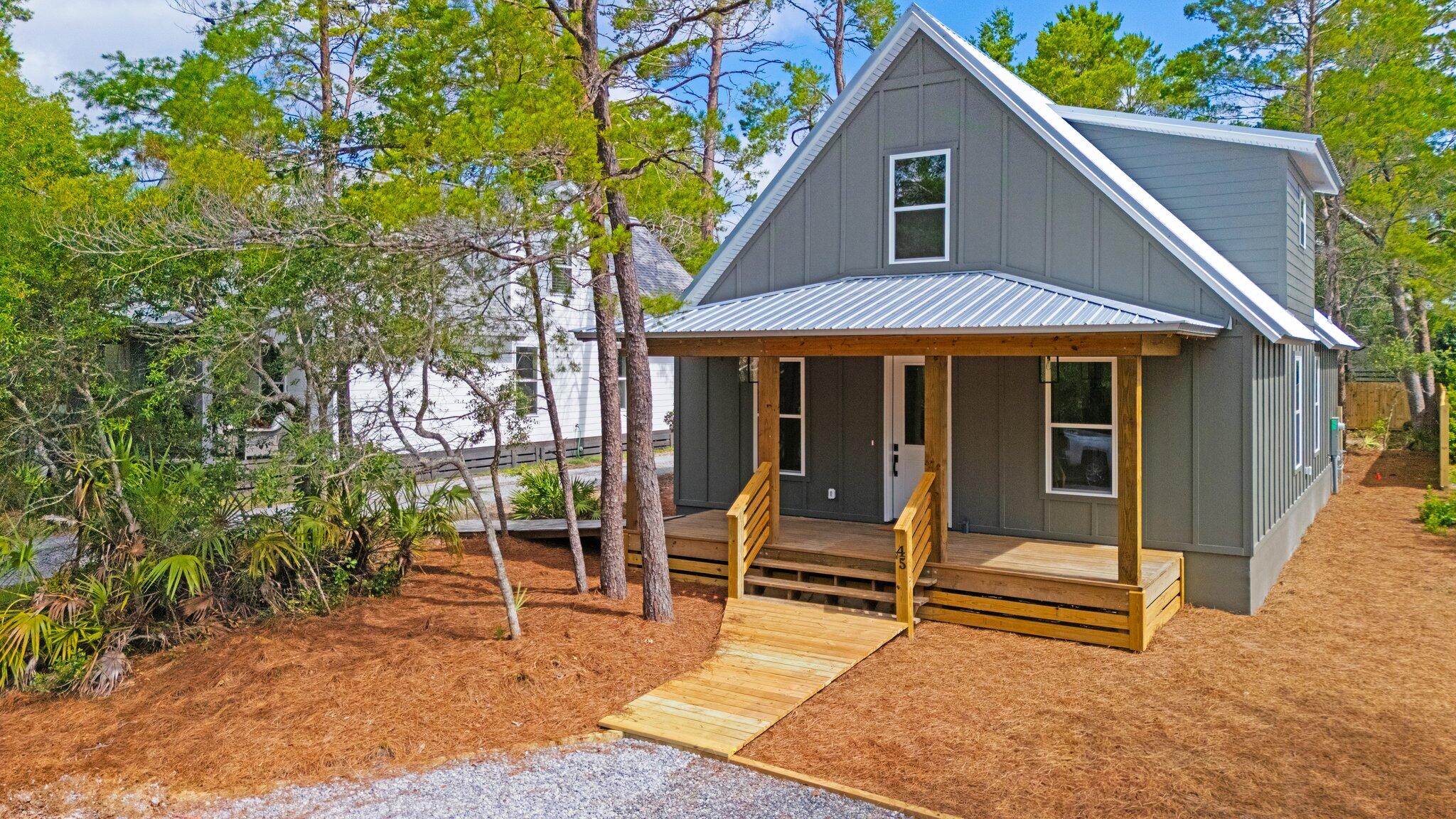 45 Laurel Oak Lane Santa Rosa Beach, FL 32459 - Photo 17 of 30 a porch with a table and chairs under an umbrella