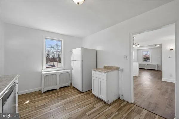 a kitchen with granite countertop white cabinets and white appliances