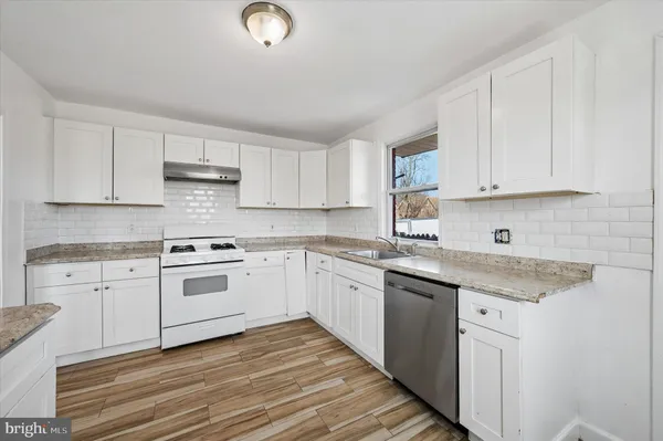 a kitchen with white cabinets and white appliances